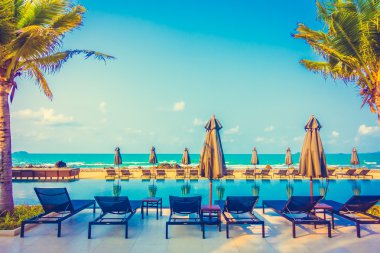 Şemsiyeleri ve sandalyeler Yüzme Havuzu etrafında