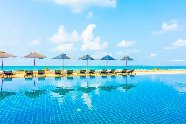 Umbrellas and chairs around swimming pool — Stock Photo, Image