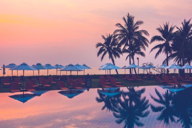 Ve Yüzme Havuzu palmiye ağaçlarının Silhouettes