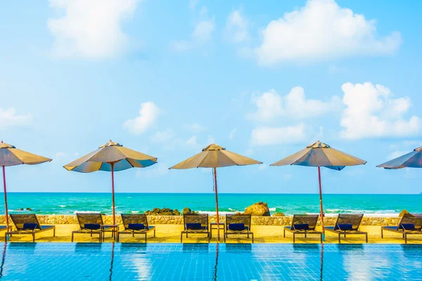 Umbrellas and chairs around swimming pool — Stock Photo, Image