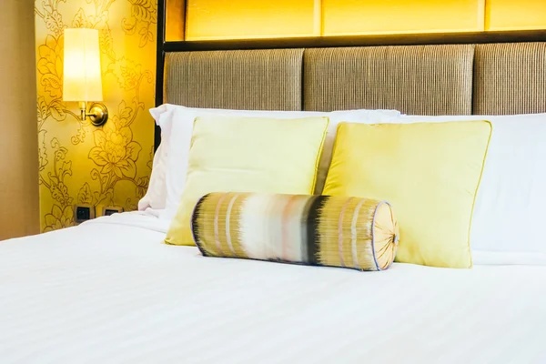 Luxusní polštáře na posteli s světlo lampy — Stock fotografie