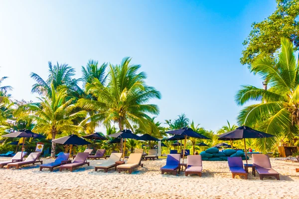 Sonnenschirme und Liegestühle am schönen tropischen Strand — Stockfoto