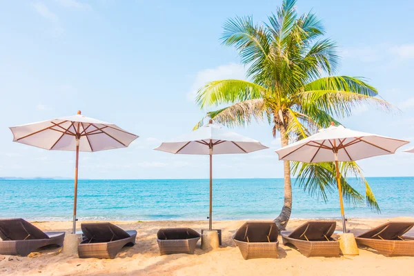 Paraply och stol på den tropiska stranden — Stockfoto