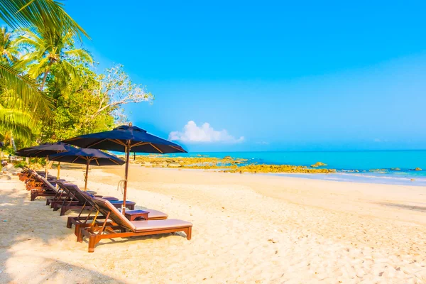 Guarda-chuvas e cadeiras na bela praia tropical — Fotografia de Stock