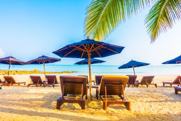 Sonnenschirme und Liegestühle am schönen tropischen Strand — Stockfoto