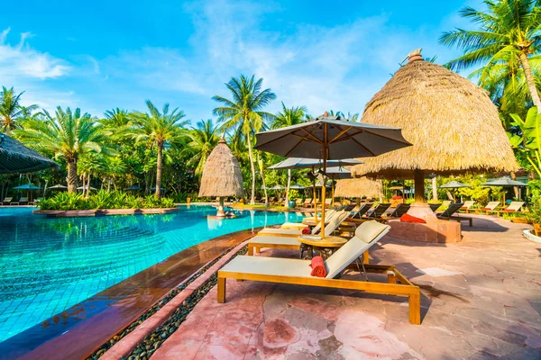 Umbrellas and chairs around swimming pool — Stock Photo, Image