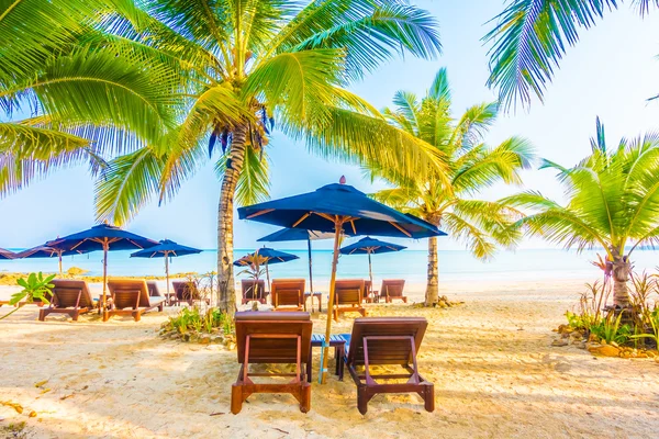 Guarda-chuva e cadeira na praia tropical — Fotografia de Stock