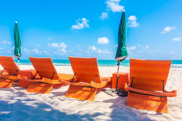 Parasol en stoel op strand — Stockfoto