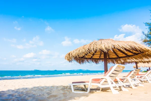 Sonnenschirm und Liegestuhl am Strand — Stockfoto