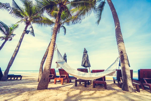 Guarda-chuva e cadeira na praia tropical — Fotografia de Stock