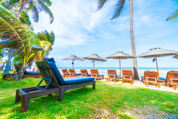Guarda-chuva e cadeira na praia tropical — Fotografia de Stock