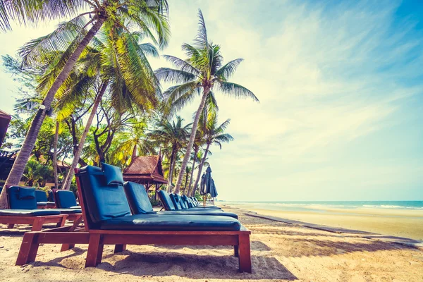 伞和坐在椅子上热带海滩 — 图库照片