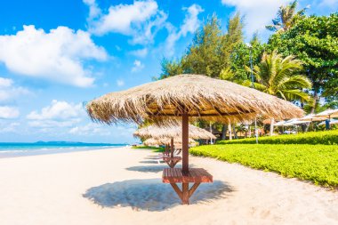 Şemsiye ve sandalye sahilde.