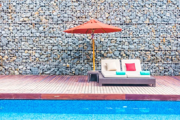 Guarda-chuva e cadeira em torno da piscina — Fotografia de Stock