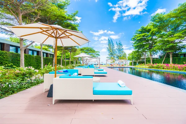 Umbrella and chair around swimming pool