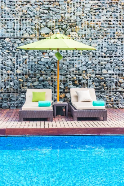 Guarda-chuva e cadeira em torno da piscina — Fotografia de Stock