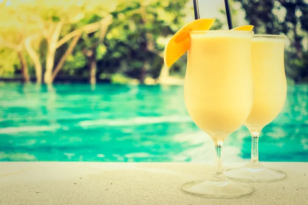 Mango juice with beautiful outdoor swimming pool — Stock Photo, Image