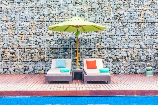 Guarda-chuva e cadeira em torno da piscina — Fotografia de Stock