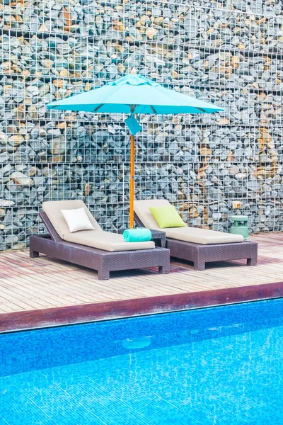 Guarda-chuva e cadeira em torno da piscina — Fotografia de Stock