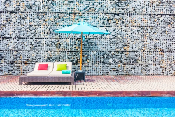 Guarda-chuva e cadeira em torno da piscina — Fotografia de Stock