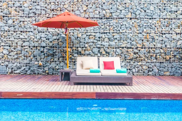 Guarda-chuva e cadeira em torno da piscina — Fotografia de Stock