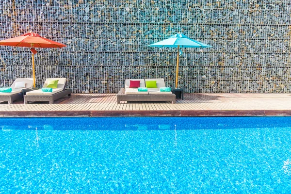 Guarda-chuva e cadeira em torno da piscina — Fotografia de Stock