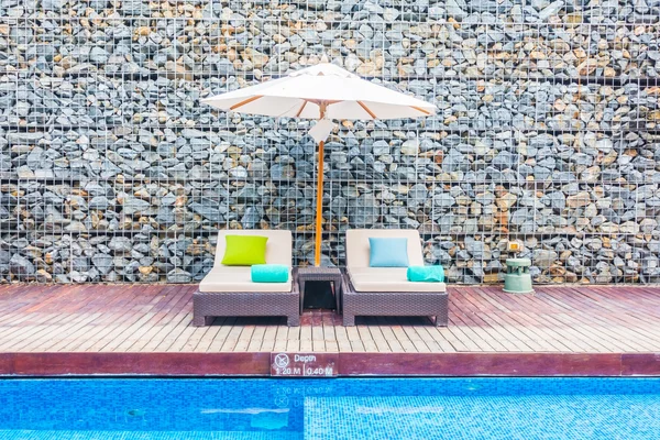 Guarda-chuva e cadeira em torno da piscina — Fotografia de Stock