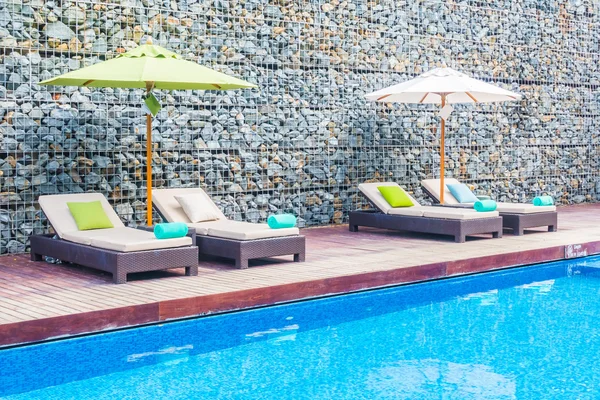 Guarda-chuva e cadeira em torno da piscina — Fotografia de Stock