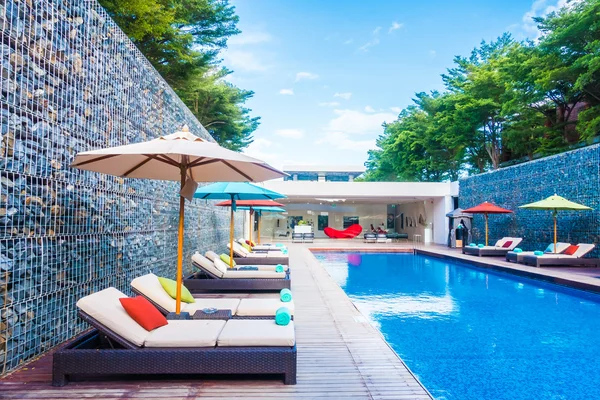 Umbrella and chair around swimming pool — Stock Photo, Image