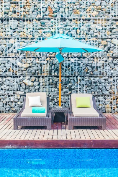 Guarda-chuva e cadeira em torno da piscina — Fotografia de Stock