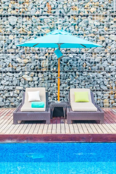 Guarda-chuva e cadeira em torno da piscina — Fotografia de Stock