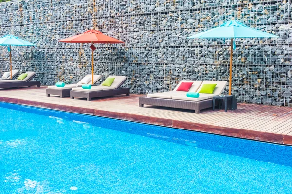 Guarda-chuva e cadeira em torno da piscina — Fotografia de Stock