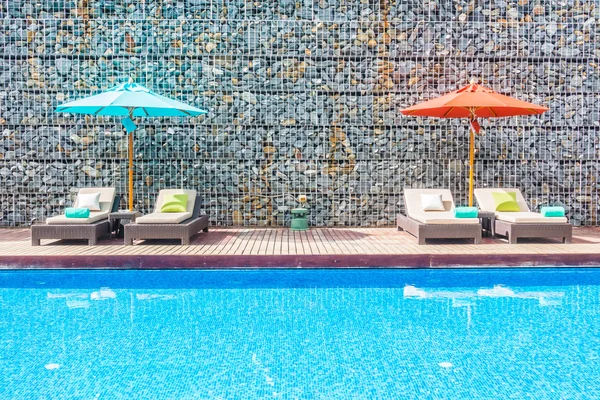 Guarda-chuva e cadeira em torno da piscina — Fotografia de Stock