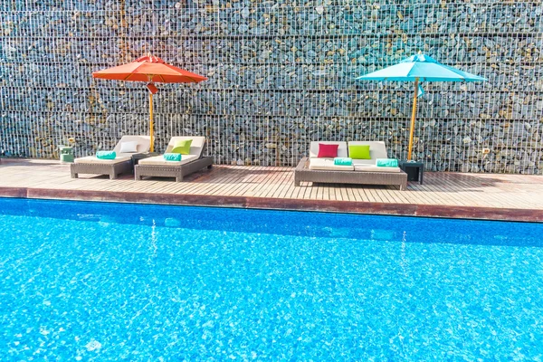 Guarda-chuva e cadeira em torno da piscina — Fotografia de Stock