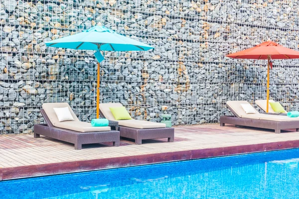 Guarda-chuva e cadeira em torno da piscina — Fotografia de Stock