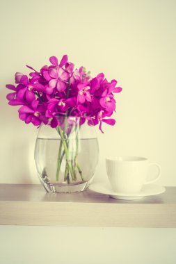 Orkide çiçek vazo ile kahve fincanı