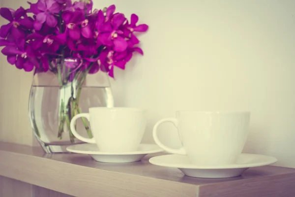Tazza di caffè con vaso di fiori di orchidea — Foto Stock