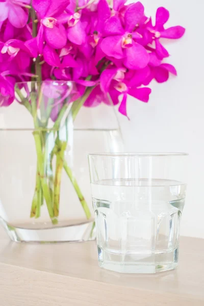 Vidro de água com orquídea — Fotografia de Stock