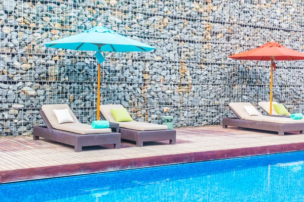 Guarda-chuva e cadeira em torno da piscina — Fotografia de Stock