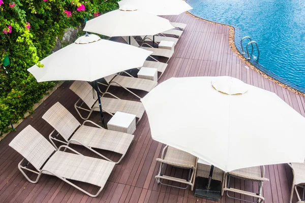 Umbrella and chair around swimming pool — Stock Photo, Image