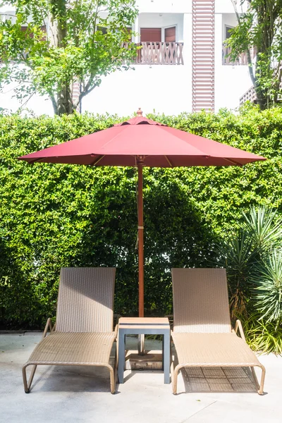 Paraguas y silla alrededor de la piscina — Foto de Stock