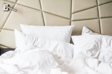 buruşuk yatak beyaz dağınık yastık ile 