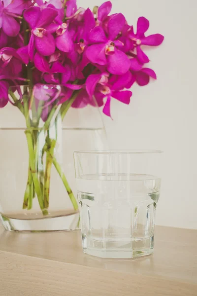 Стакан воды с цветком орхидеи — стоковое фото