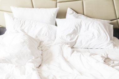 buruşuk yatak beyaz dağınık yastık ile 