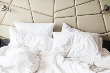 buruşuk yatak beyaz dağınık yastık ile 