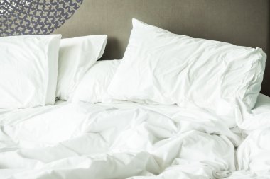 buruşuk yatak beyaz dağınık yastık ile