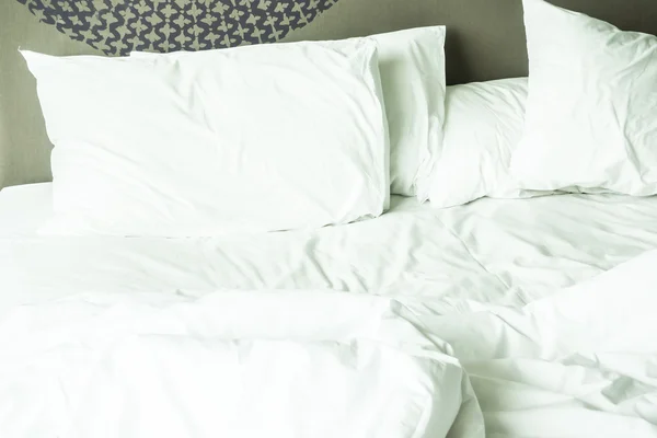 Rumpeliges Bett mit weißem, unordentlichem Kissen — Stockfoto