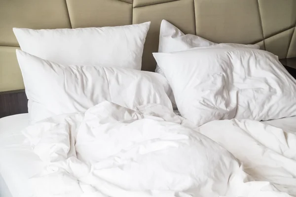 Rumpled bed with white messy pillow — Stock Photo, Image