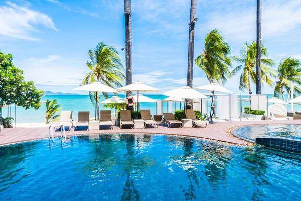 Paraguas y silla alrededor de la piscina — Foto de Stock