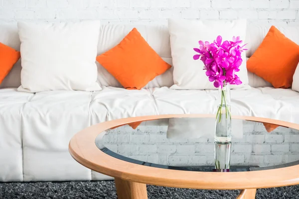 Vaso flor com travesseiro no sofá — Fotografia de Stock
